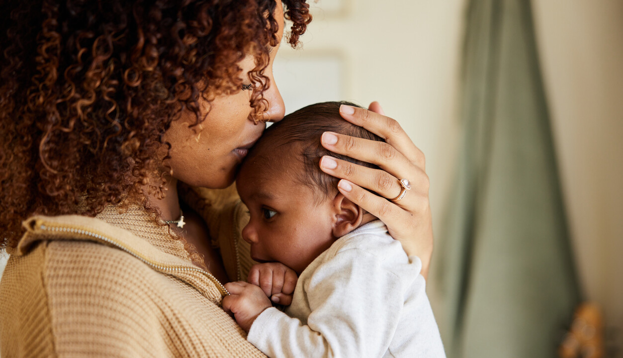 mother kissing babies forehead.