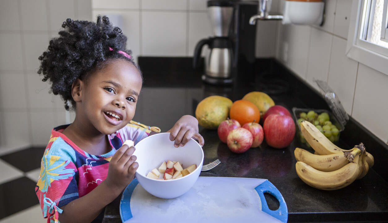 little girl with a bowl of apple slices.